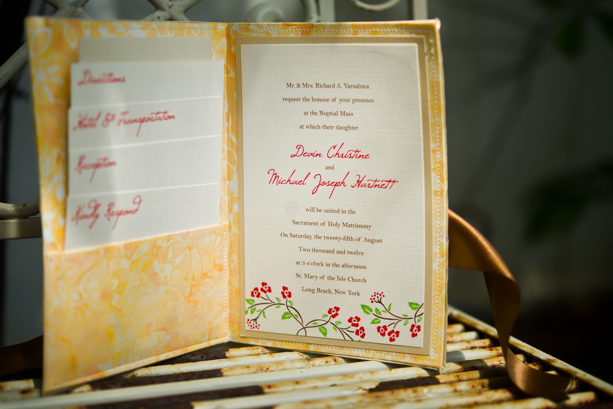 The invitation open &mdash; coral ink against the yellow floral lining