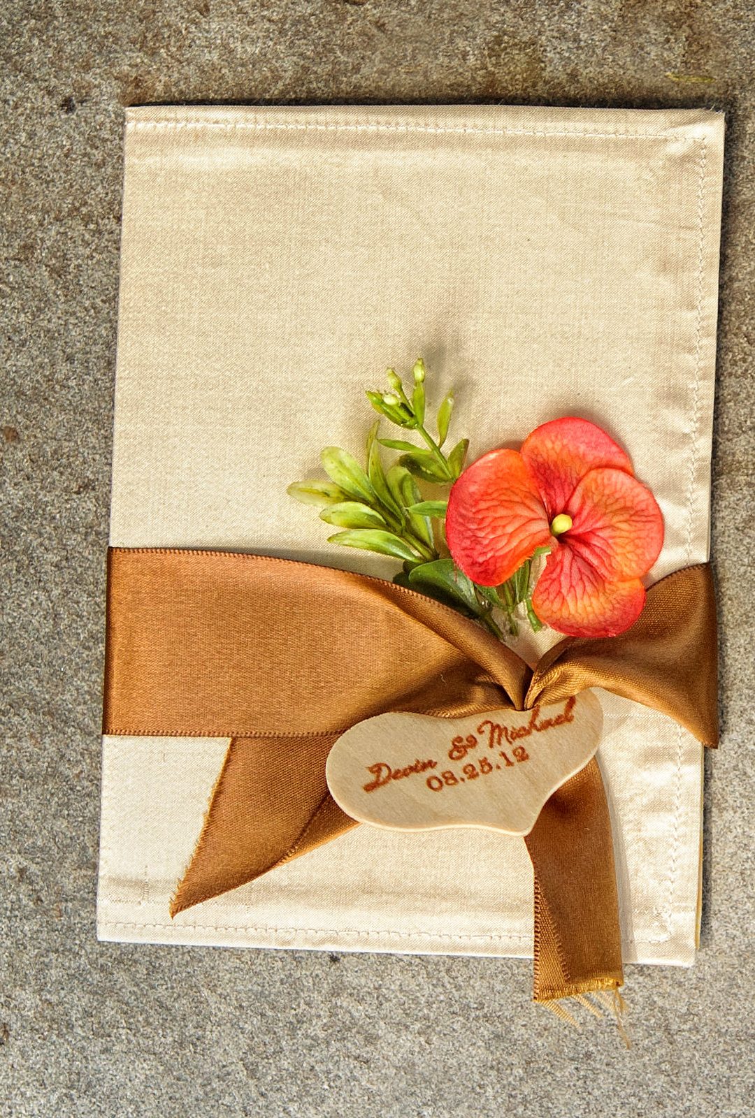 The outside of the invitation &mdash; champagne silk, satin ribbon, and a wood heart tag