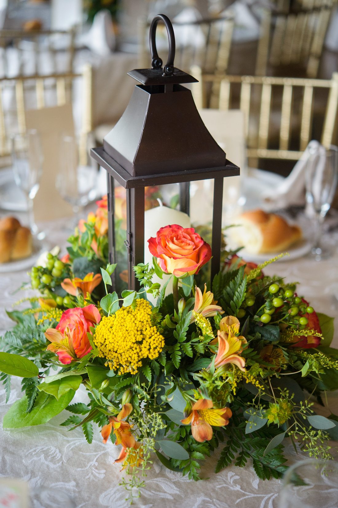 A lantern centerpiece ringed with flowers
